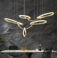 Duża lampa wisząca mosiężna LED z ciepłym światłem, idealna nad stół w nowoczesnej jadalni.